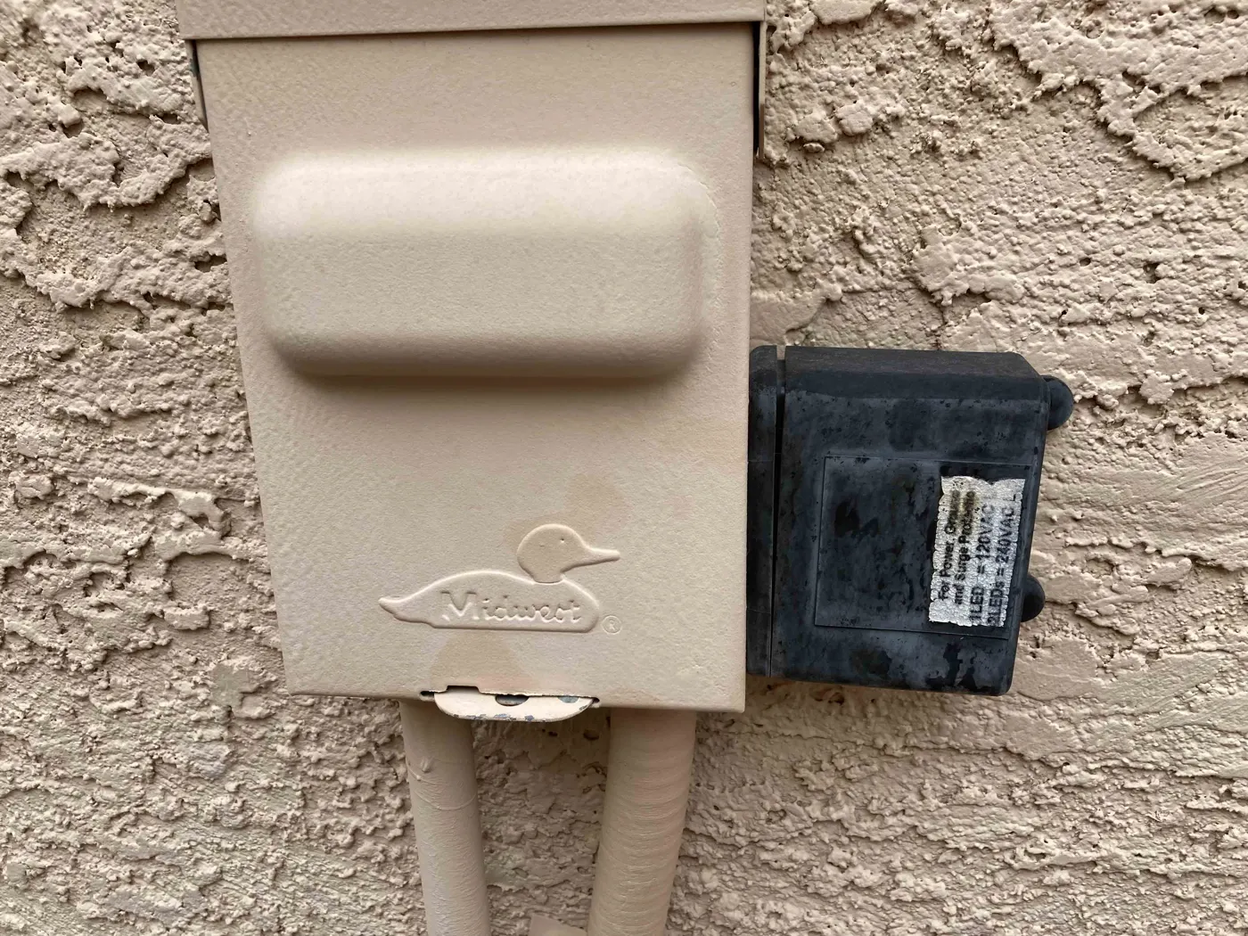 Outdoor electrical disconnect box on a stucco wall